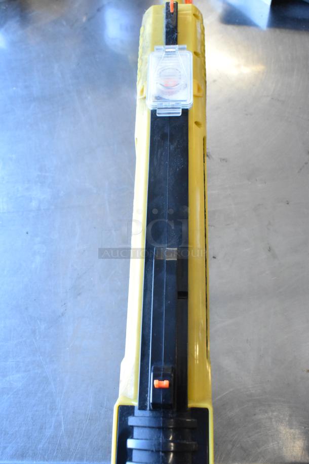 Yellow and black GiveBest PTC-905 salt gun on a metallic surface, visible trigger and clear compartment.