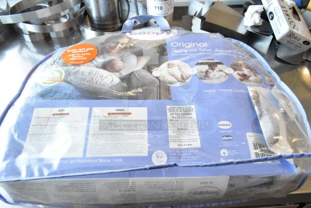 Boppy Original Feeding and Infant Support Pillow in packaging, featuring a cottony cute design, includes product info and labels.