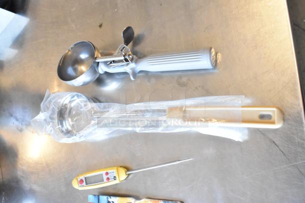 Lot of utensils including a metal scooper, ladle, and digital thermometer on a metal surface. Items appear gently used.
