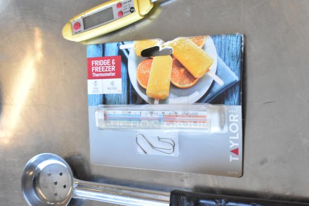 Lot of utensils including spoodles, ladles, and a Taylor fridge and freezer thermometer. Items appear in good condition.