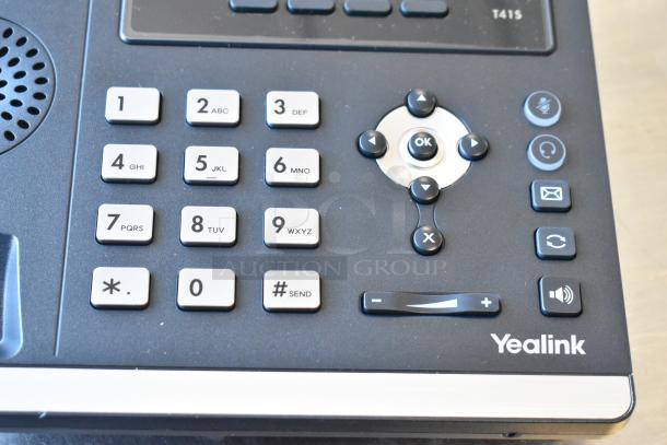 Yealink corded telephone with keypad and navigation buttons, in good condition, part of a 4-item auction bundle.