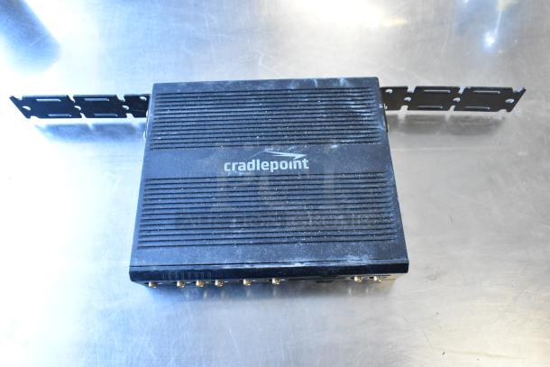 Cradlepoint AER2200 router, black, visible ports, used condition, shown on metal surface.