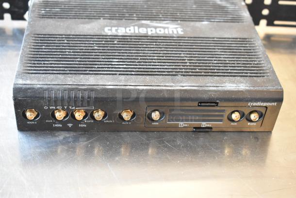 Cradlepoint AER2200, black, multiple ports, visible wear, labels for VPN, Wi-Fi, GPS. Auctioned with three other items.