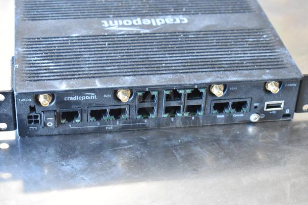 Cradlepoint AER2200 router with multiple ports, fair condition, visible labels showing connection types and frequency.