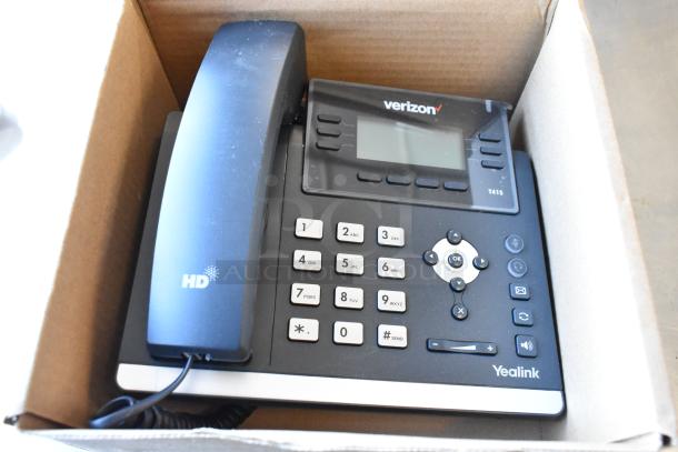 Verizon corded telephone in an open box, features keypad and display. Includes brand logo and HD marking.