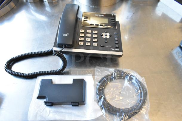 Yealink Verizon corded telephone with HD handset, keypad, and display screen. Includes stand and coiled cable in packaging.