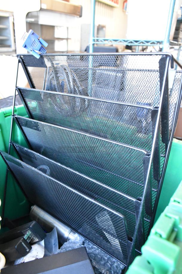 Lot of various items in a green poly bin; includes metal mesh organizer, electrical plug, and bubble wrap contents.