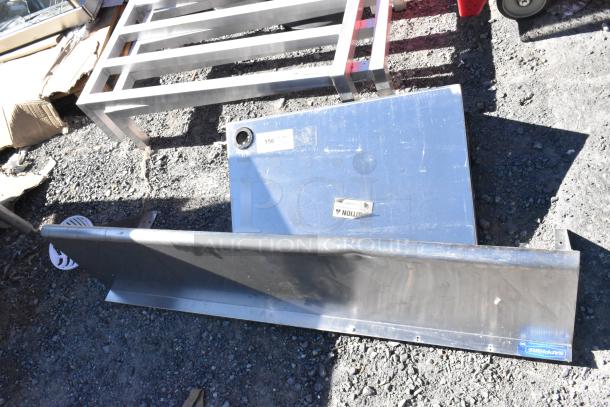 Two metal wall mount shelves with visible tags. Includes 48x12x12 size. Used condition. Labels show item 156 and caution symbol.