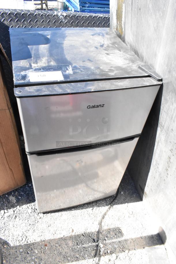 Galanz GLR31TS1E02 mini cooler with freezer, silver finish, visible signage, powered by 115 volts, 1 phase. Some surface wear.