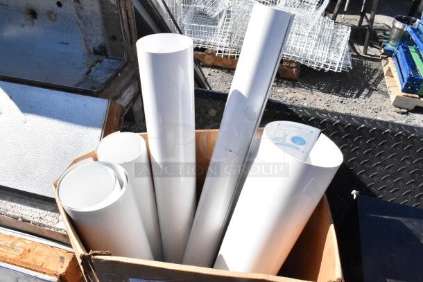 Box of white material rolls, various sizes, in good condition. Visible label on one roll. Suitable for crafting or industrial use.
