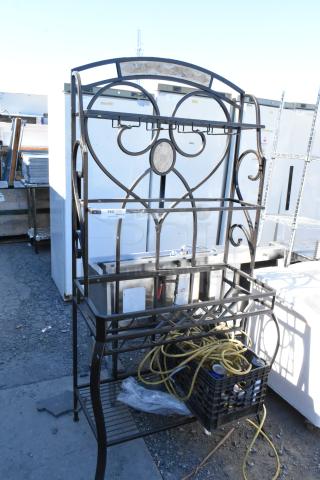 Metal frame with decorative design, containing a plastic crate with yellow rope and miscellaneous items. Used condition.