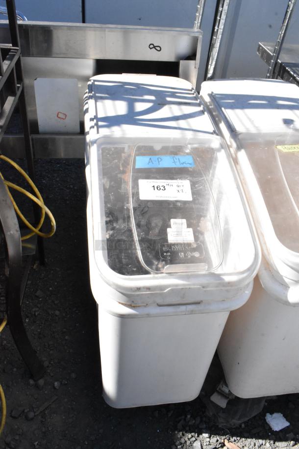 Two white poly ingredient bins on commercial casters, labeled "A.P. flour." Good condition, clear lids, markings visible.