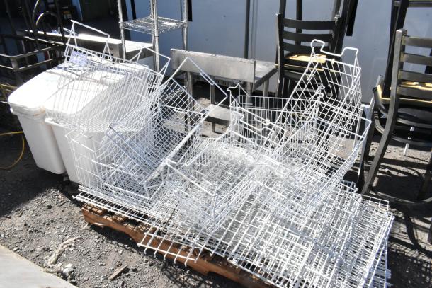 Pallet of various items including multiple white poly freezer baskets, metal chairs, and shelving units, outdoor setting.