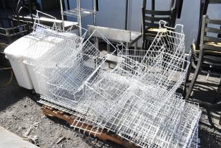 Pallet of various items including multiple white poly freezer baskets, metal chairs, and shelving units, outdoor setting.