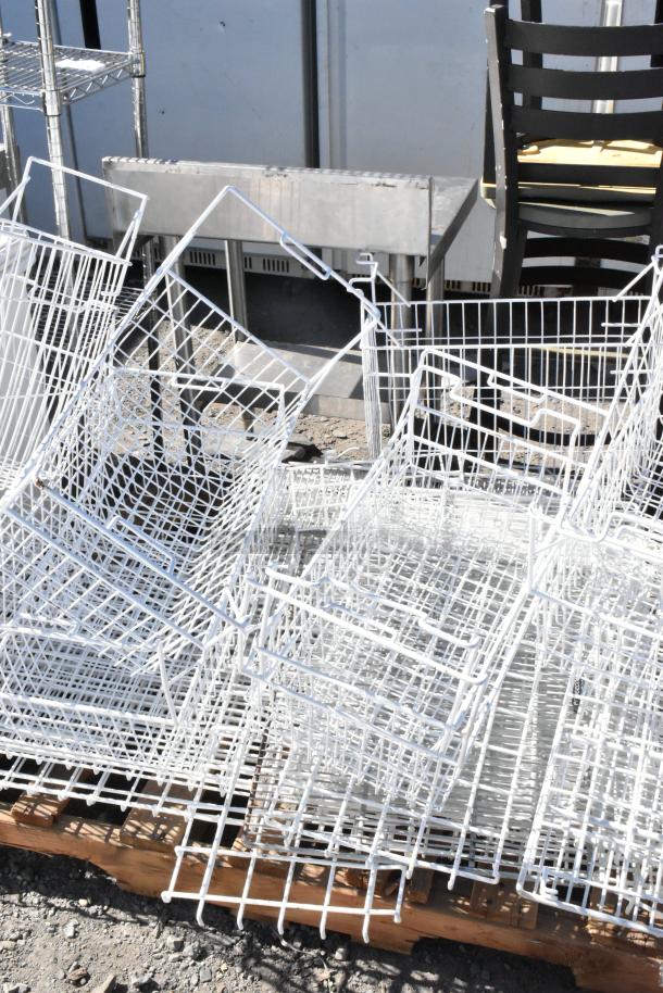 Pallet lot of white poly freezer baskets in various sizes, stacked and in used condition.