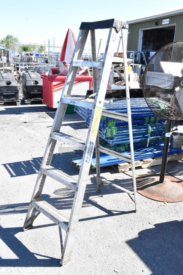 6' Louisville A-frame ladder in used condition, aluminum with visible labels and stable design, ideal for construction tasks.