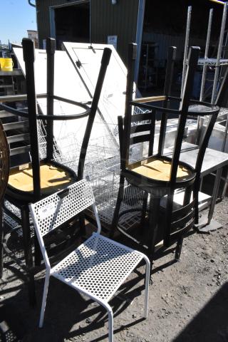 Five various chairs including a black metal bar height chair, stacked outdoors. Features include black and white finishes. Item tag visible.