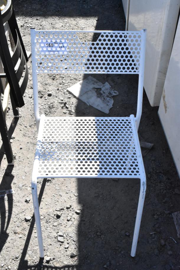 White perforated metal chair on dirt ground, part of a 5-chair auction lot. Visible wear and auction tag "168".