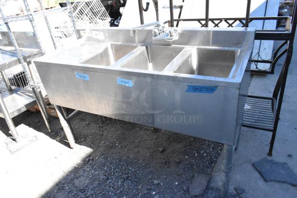 Regency 600B3101413LFT stainless steel 3 bay sink with left side drain board. Labeled wash, rinse, sanitize. Good condition.