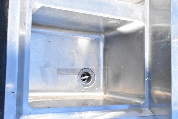 Regency 600B3101413LFT stainless steel 3-bay sink with left side drain board, visible wear, durable construction.