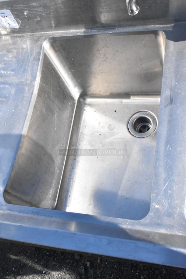 Regency stainless steel 3 bay commercial sink with left drain board, model 600B3101413LFT. Visible minor wear.
