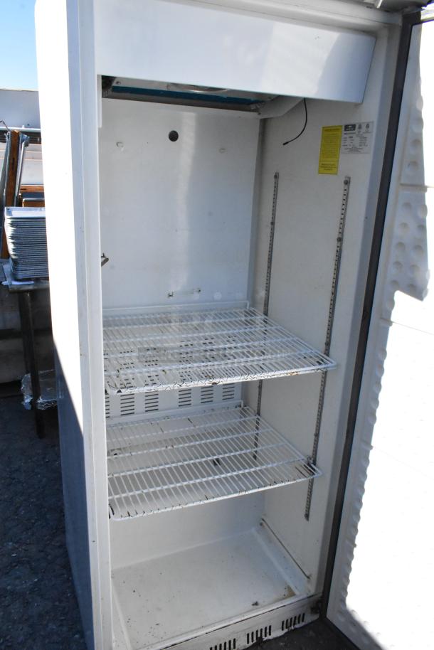 Arctic Air AWR25 metal single door reach-in cooler, 115 volts, 1 phase, shows interior shelves, minor wear visible.