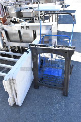 Four items: folding table, sign, saw horse, and wire basket. Used condition. Ideal for versatile applications.
