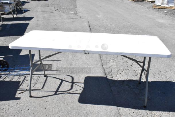Four varied items including a white folding table, street sign, saw horse, and basket. Table shows slight wear.