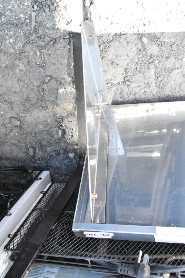 Metal wall mount shelf with a minimalist design, featuring a metallic finish and visible mounting brackets. Suitable for home or office use.