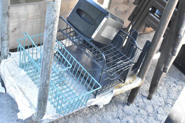 Stainless steel table with contents, including teal wire baskets and full-size baking pans. Good condition.