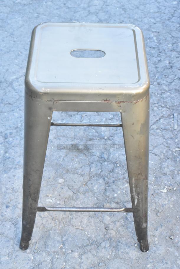 Metal Tolix style bar height stool; worn appearance with scratches; square seat with cutout handle.