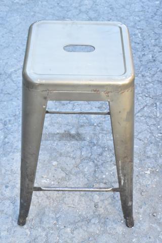 Metal Tolix style bar height stool; worn appearance with scratches; square seat with cutout handle.