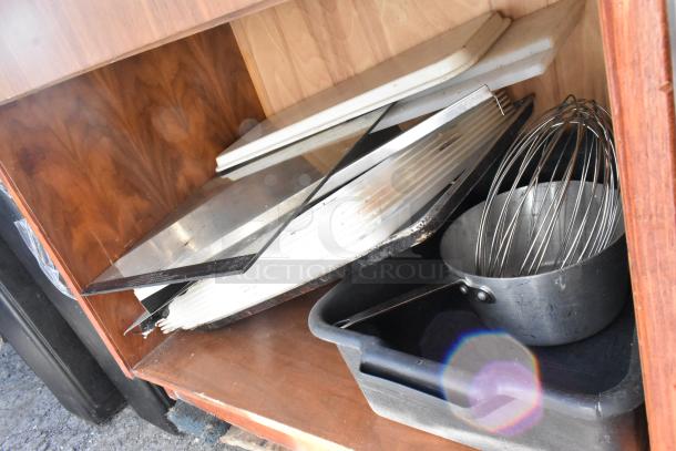 Wood pattern stand with two drawers, containing various kitchen trays and a large whisk, slight wear on edges.