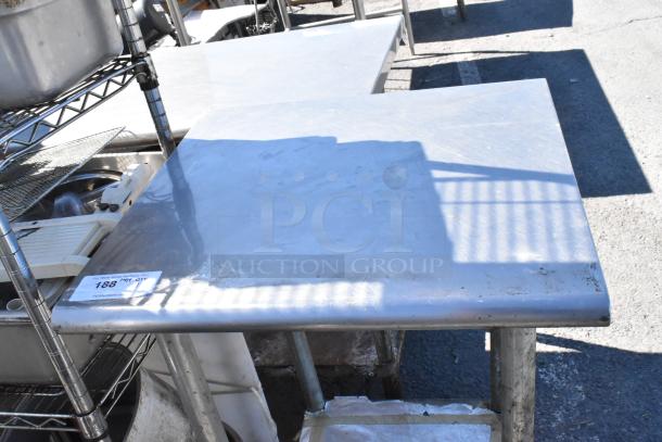 Stainless steel table with metal under shelf, visible wear; auction tag "188" attached to corner.