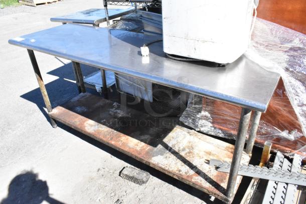 Stainless steel table with metal under shelf, used condition, some surface wear visible. Ideal for kitchen or workshop use.