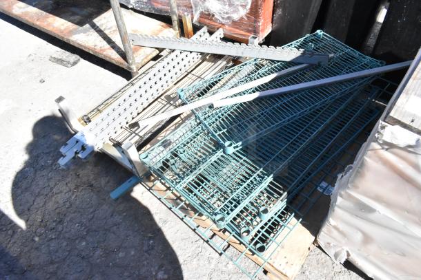 Pallet lot with metal dunnage rack and wire shelves in various conditions, positioned on a wooden pallet outdoors.