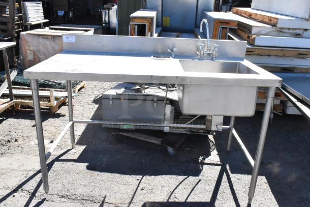 Stainless steel table with sink basin, faucet, and handles. Good condition, includes backsplash and open under-shelf.