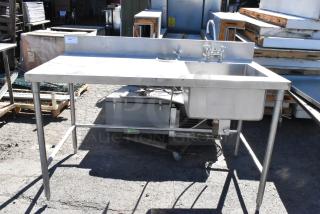 Stainless steel table with sink basin, faucet, and handles. Good condition, includes backsplash and open under-shelf.