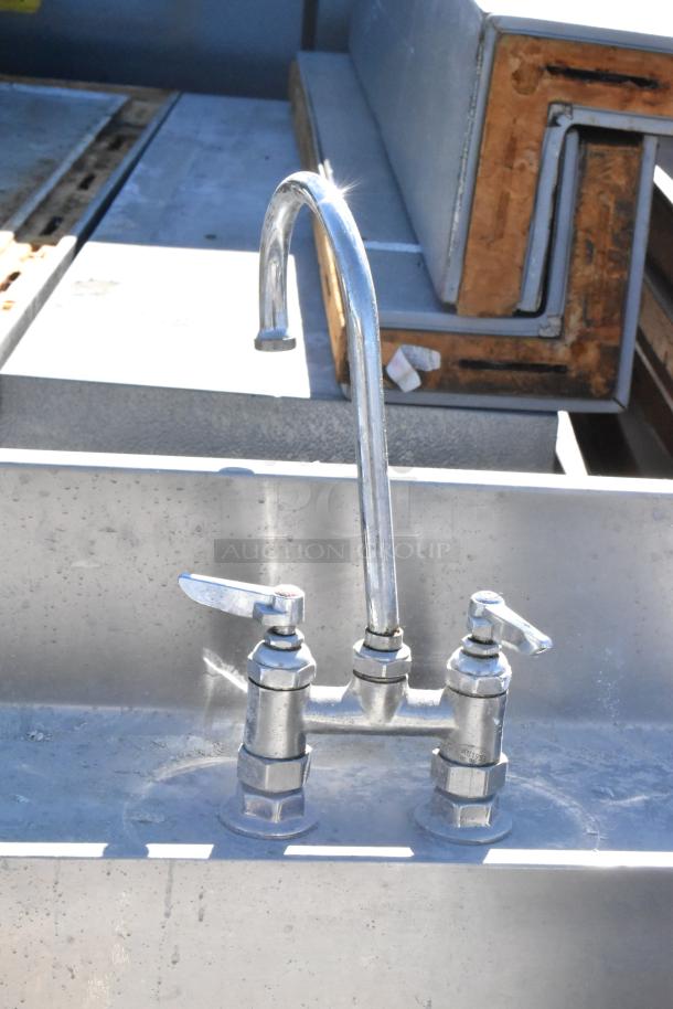 Stainless steel table with integrated sink basin, faucet, and dual handles, in used condition, suitable for kitchen use.