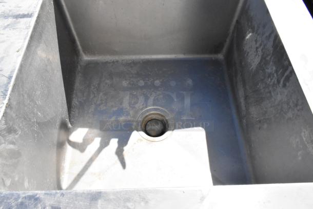 Stainless steel sink basin with integrated table, visible drain, worn condition, includes faucet and handles.