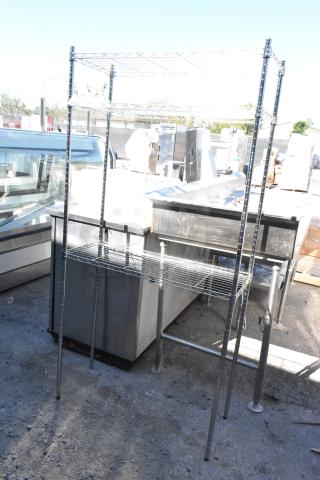 Chrome finish 3-tier wire shelving unit, tall structure, buyer dismantle required, ideal for storage and organization.