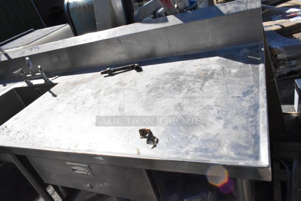 Stainless steel table with sink basin, faucet, handles, drawer, and under shelf. Scratched surface, used condition.