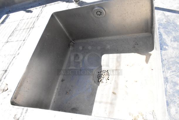 Stainless steel table with sink basin, faucet, handles, drawer, and under shelf. Slightly worn condition.