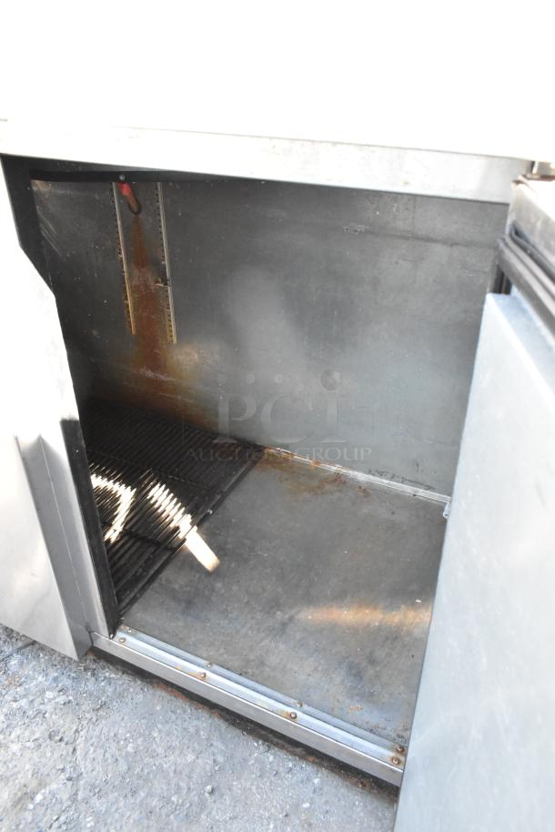 True TBB-3-S stainless steel commercial undercounter cooler with two doors, interior view showing shelves and storage area.
