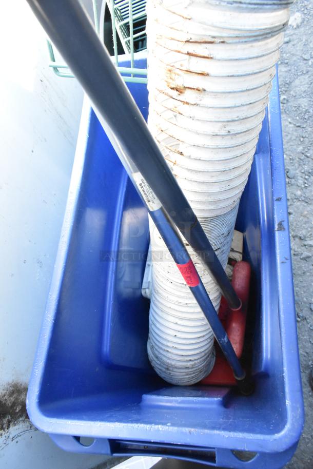 Blue poly bin containing wall mount storage unit pieces and pipes, shown outdoors. Bin is in used condition.