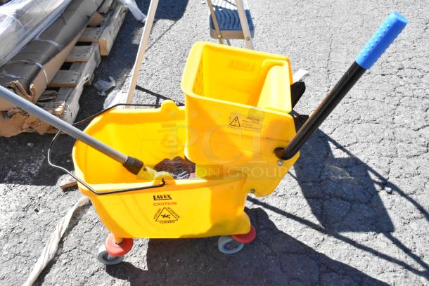 Yellow Lavex mop bucket with caution label, includes mop handle and wringer. 3-step ladder visible in background.