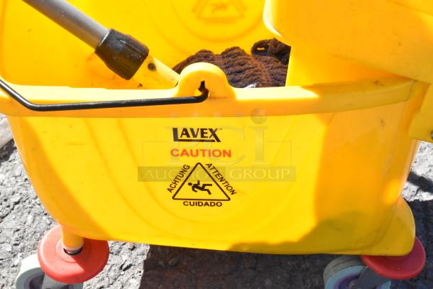 Lavex mop bucket with caution label, yellow plastic, red wheels, includes mop handle.