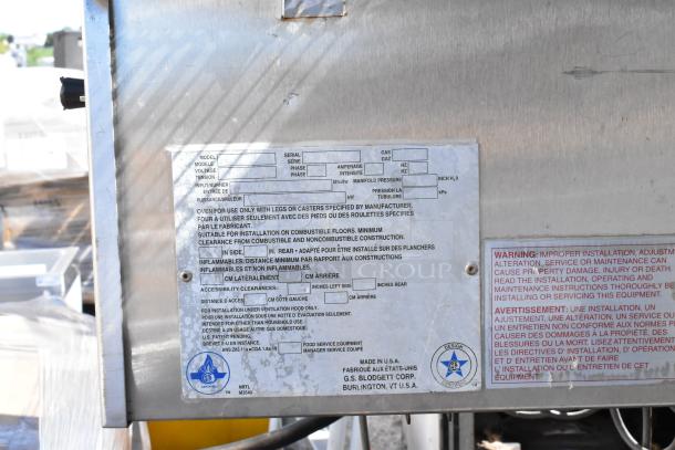 Blodgett stainless steel conveyor pizza oven with commercial casters, 208-240 volts, 3 phase. Label shows installation and safety warnings.