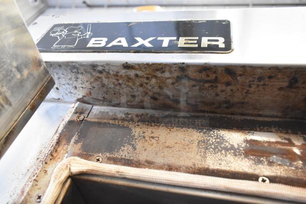 Baxter stainless steel commercial rotating rack oven showing wear, with visible logo. Features double pan rack and casters.