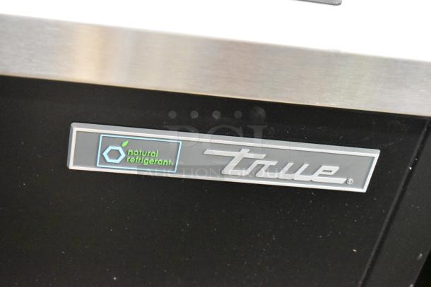 True TD-50-18-HC cooler, metal, new with scratches, 115V, 1 phase, sliding lids, "natural refrigerant" label displayed.